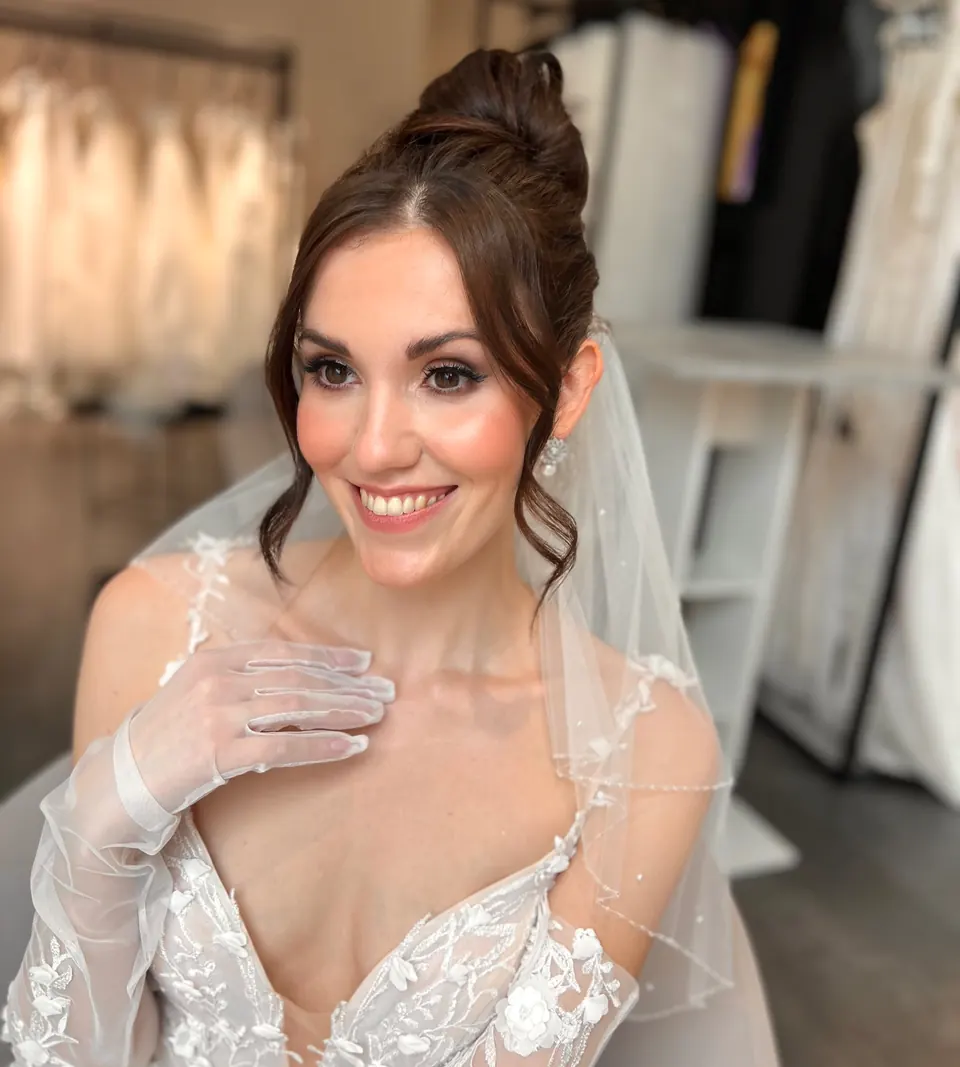 Braut mit hohem Dutt, Schleier und strahlendem Braut-Make-up in München
