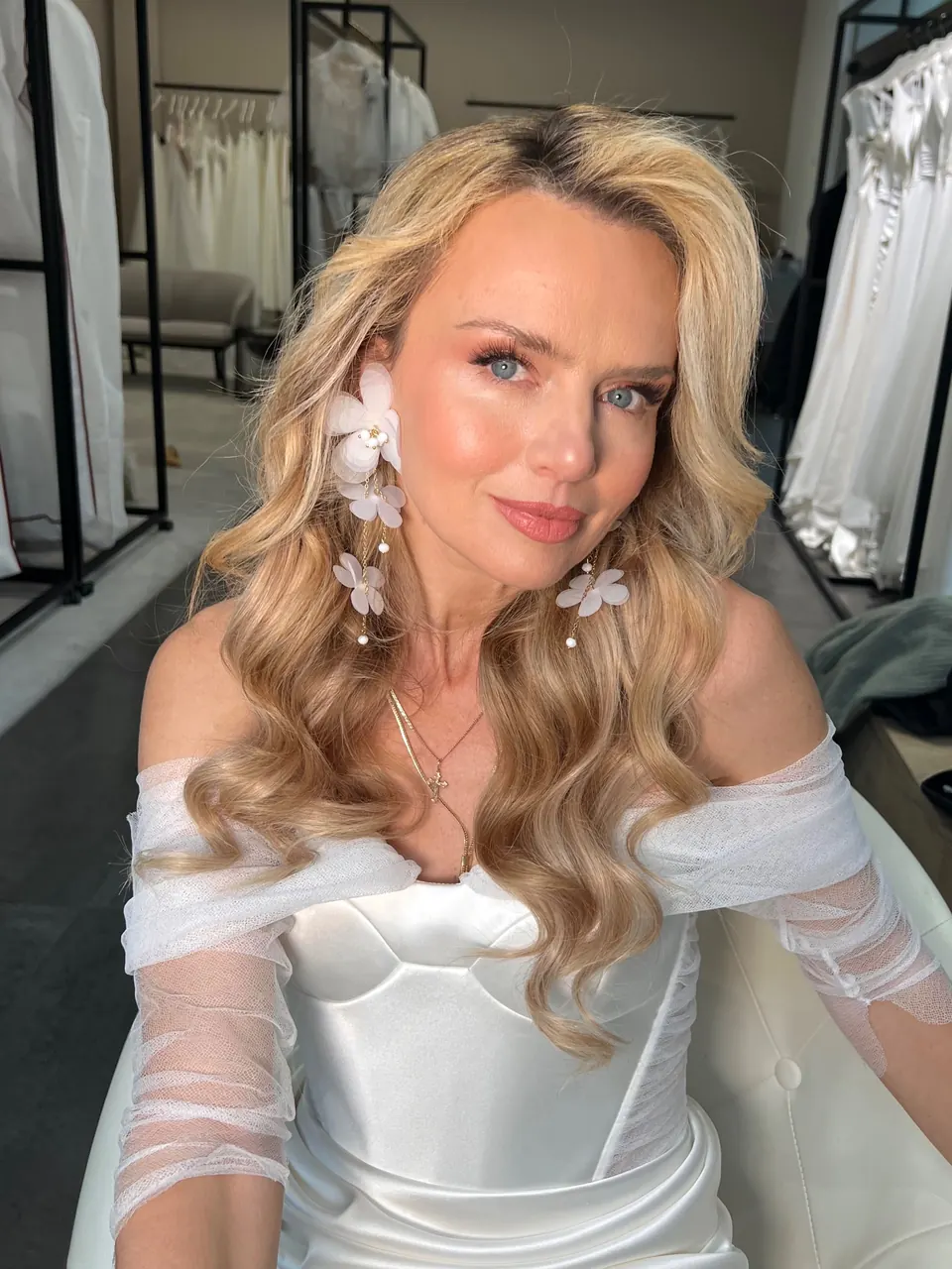 Braut mit offenen blonden Wellen und Blüten im Haar – Brautstyling in München